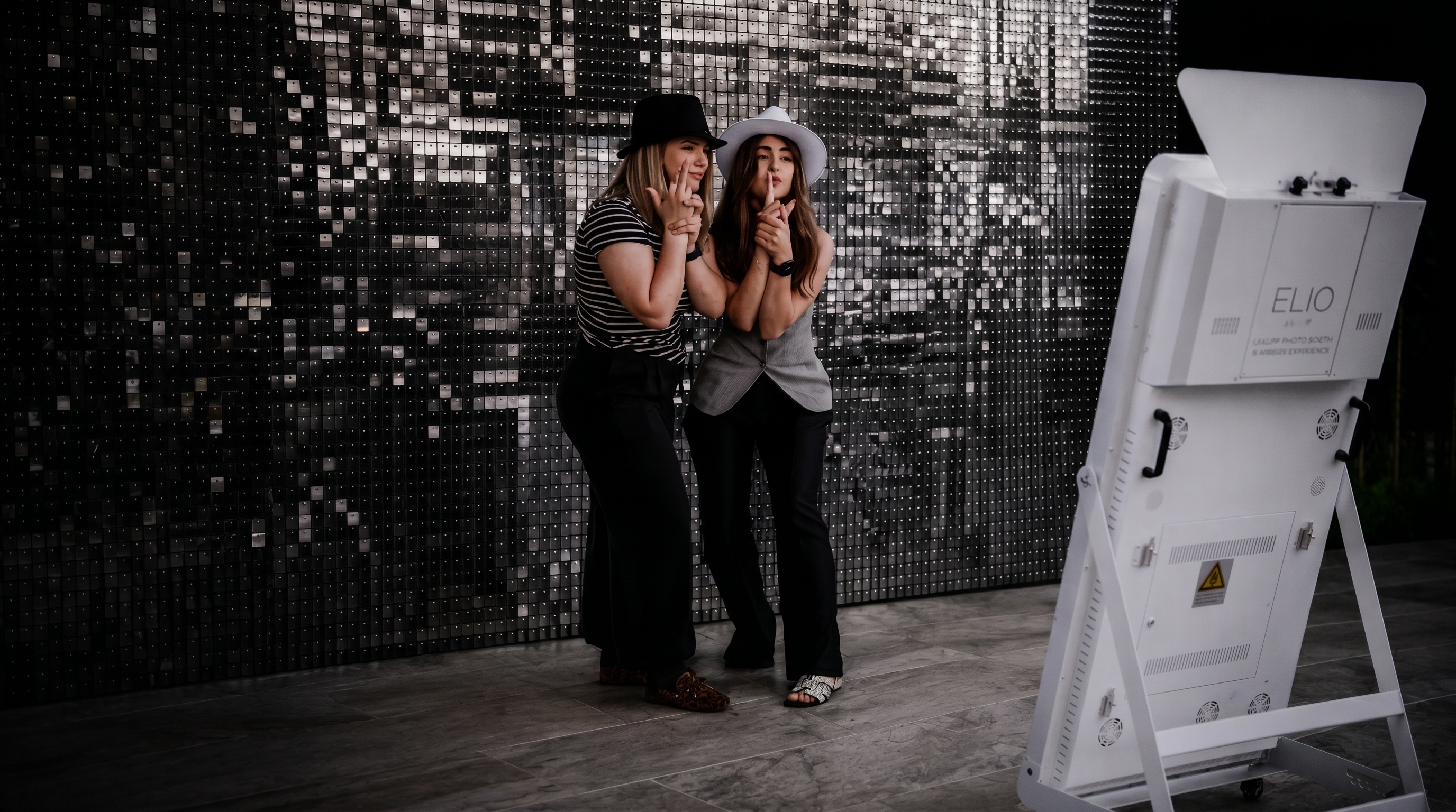Guests taking a natural DSLR photo with the ELIO Mirror Booth